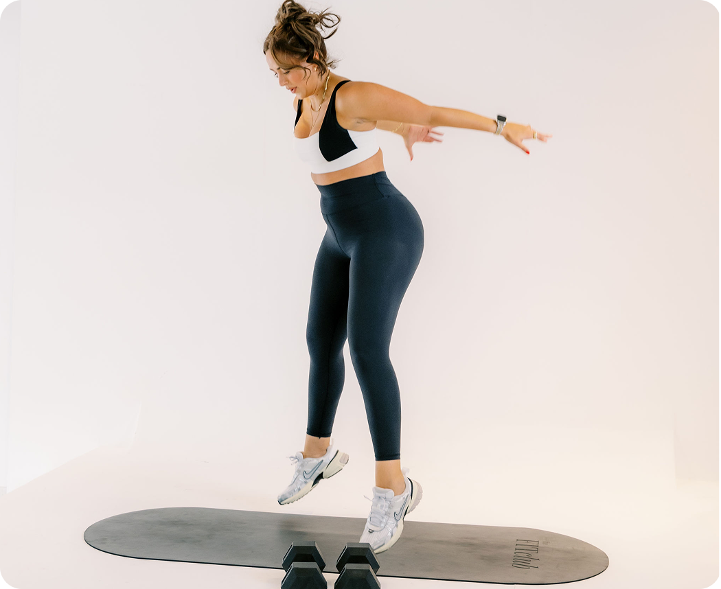 Woman doing jumping squats for a HIIT workout class by The FITclub, an online community of real women and real bodies. 