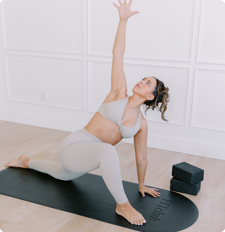 Woman doing an online yoga class by The FITclub, an online community of real women and real bodies. 